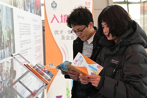濟南民眾在巡迴展覽 —— 濟南站的展館內參觀，細心閱讀現場免費派發的小冊子。