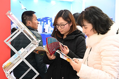 合肥民眾在巡迴展覽 —— 合肥站的展館內參觀，細心閱讀現場免費派發的小冊子。