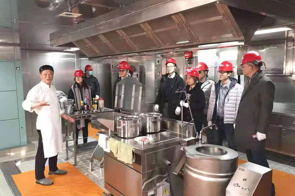 駐滬辦同事與船上廚師（左）交談