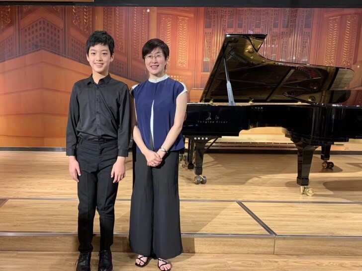 駐滬辦主任蔡亮（右）與香港少年演奏家吳優男（左）合影