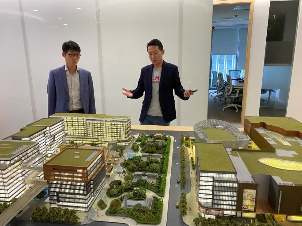 中國新天地虹橋項目助理總經理陸璽（右一）向經貿關係總監龐錦輝（左一）介紹虹橋項目總體情況