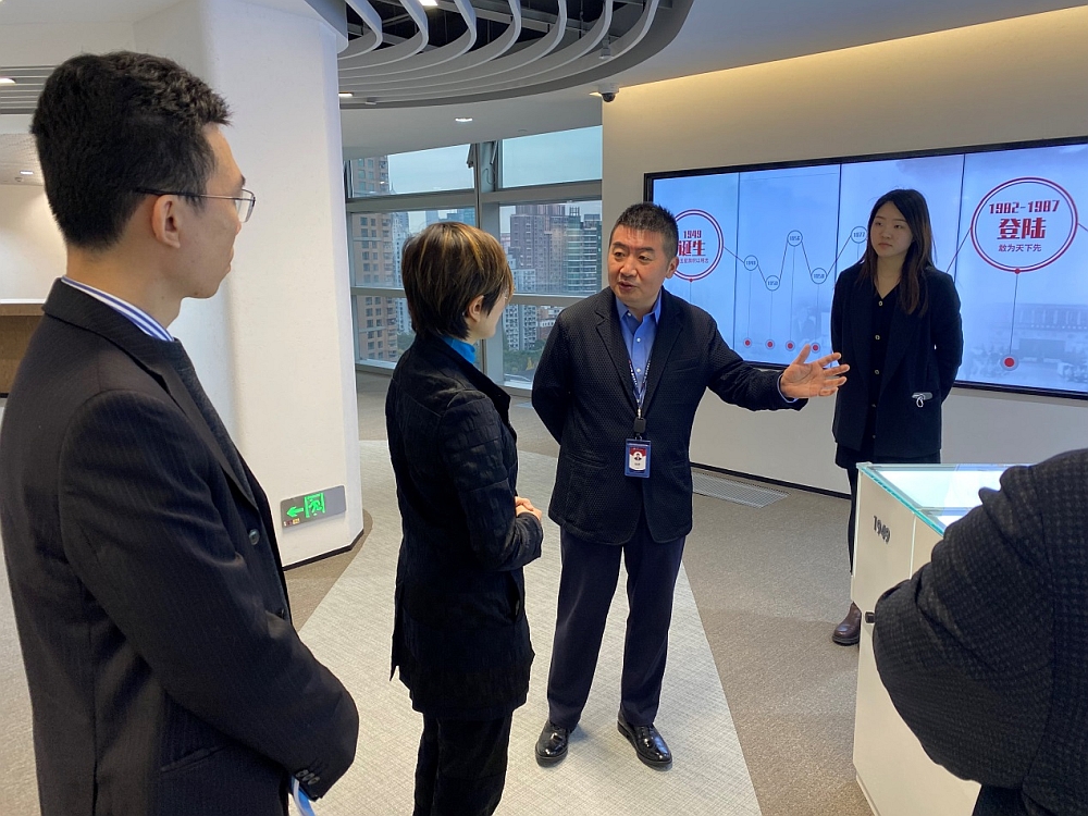 孫建東董事長（右二）向蔡亮主任（左二）介紹南洋商業銀行行史和創始人莊世平先生的愛國事跡
